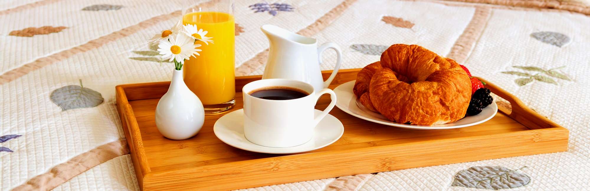 Tray with breakfast on a bed in a hotel room