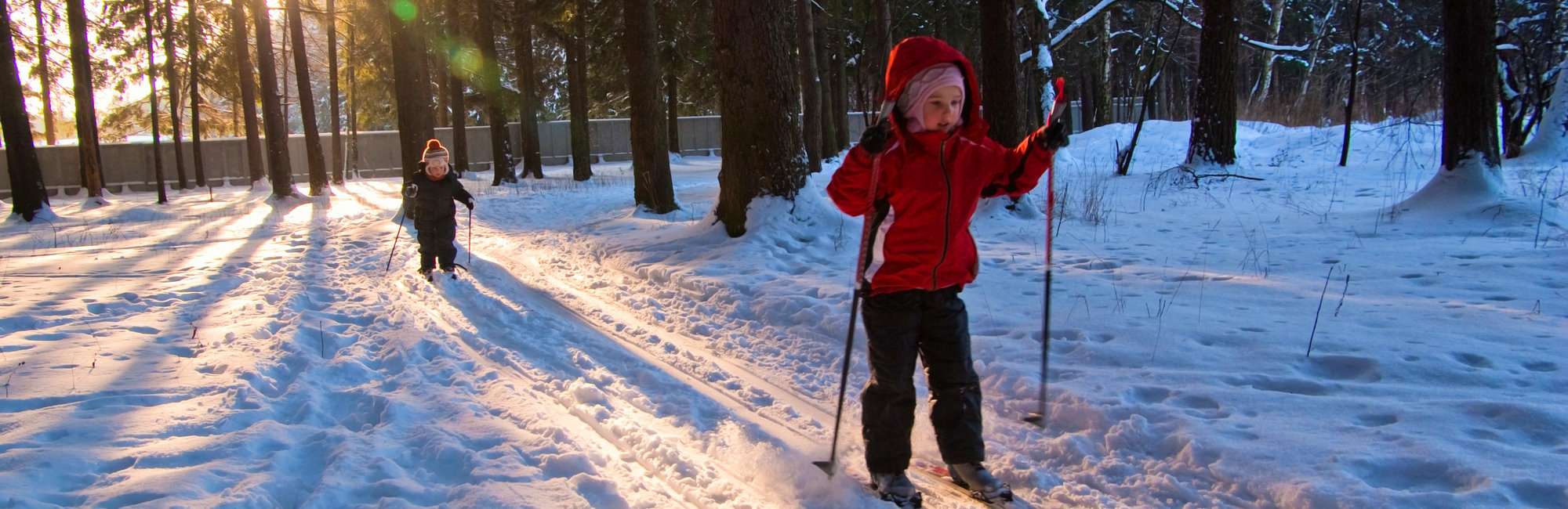 Little Girl and Boy Cross Country Skiing. Focus on girl in red