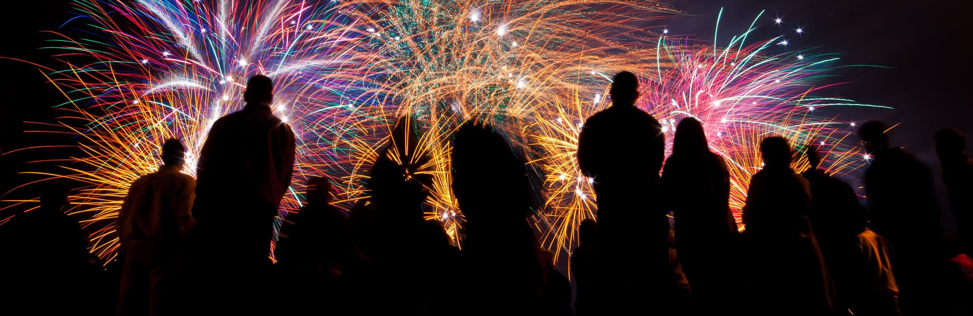 Big fireworks with silhouettes of people watching it