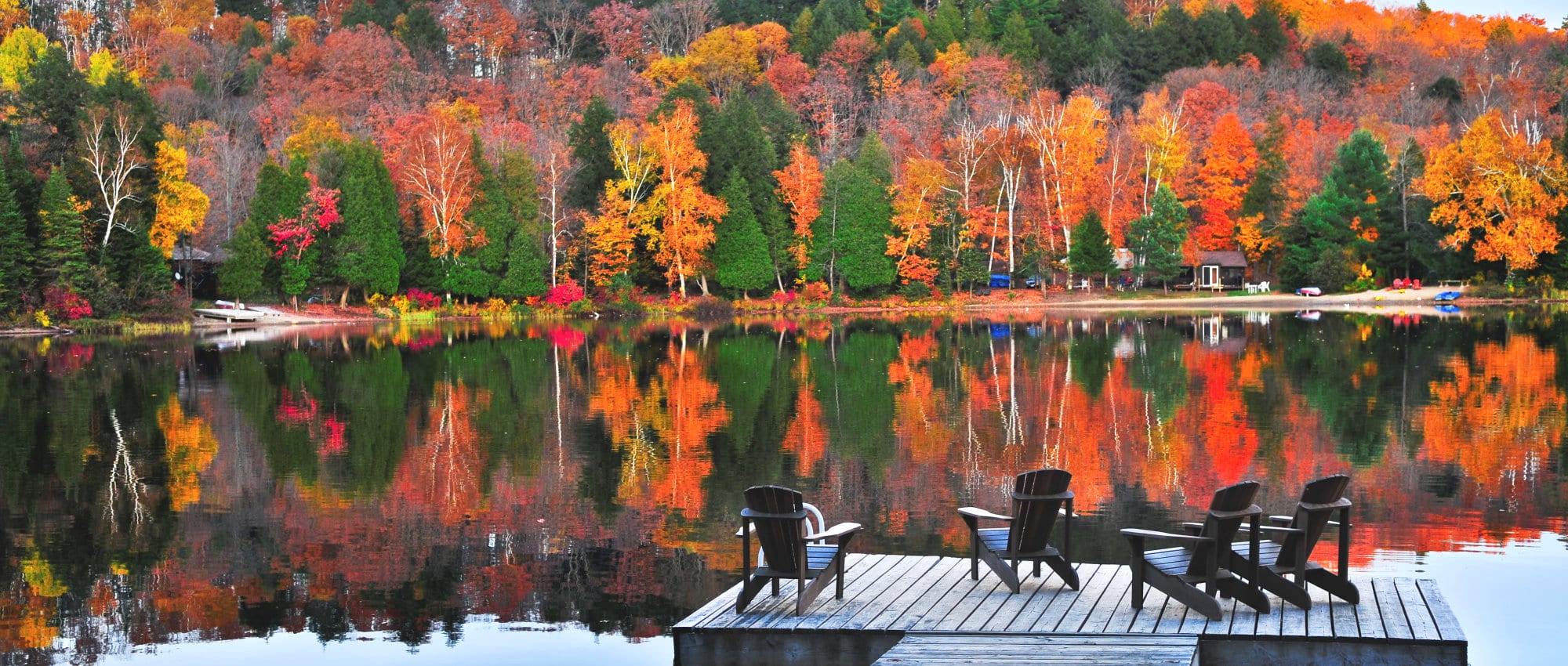 Wooden dock with chairs on calm fall lake Wooden dock with chairs on calm fall lake