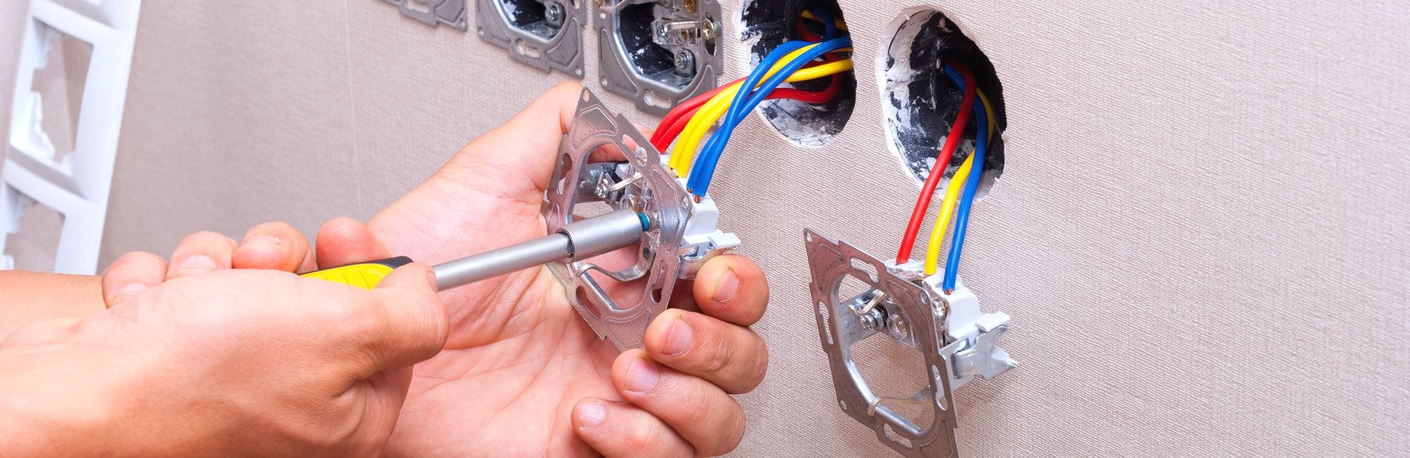 electrician connects the sockets to the electrical wires on the wall